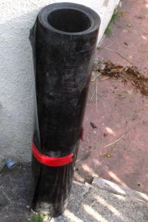 Bamboo barrier made from thick black plastic rolled up into a tube.