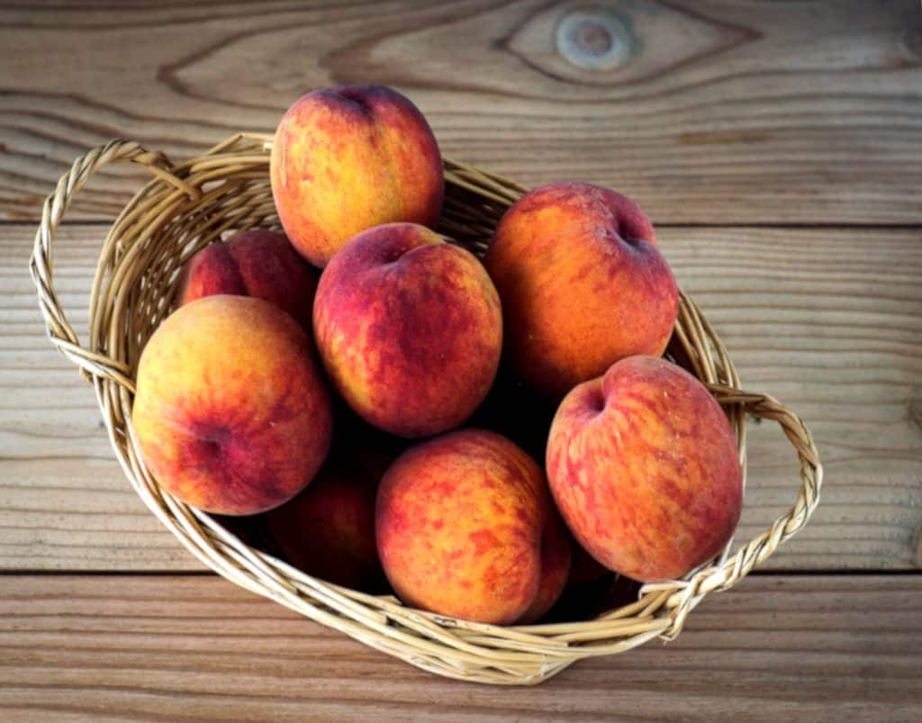 Peaches in a basket, ready for a delicious bite of health benefits