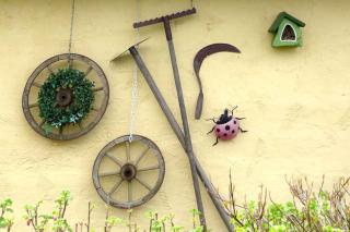Tools and old wheels set up on a wall