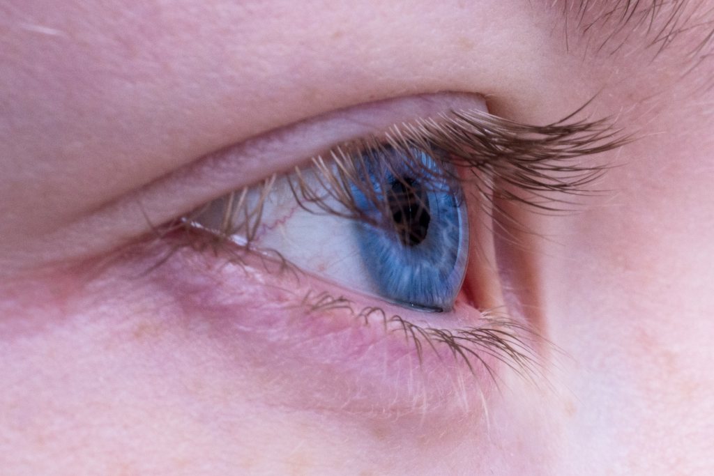 A close-up of a blue-eyed person's eyelid.