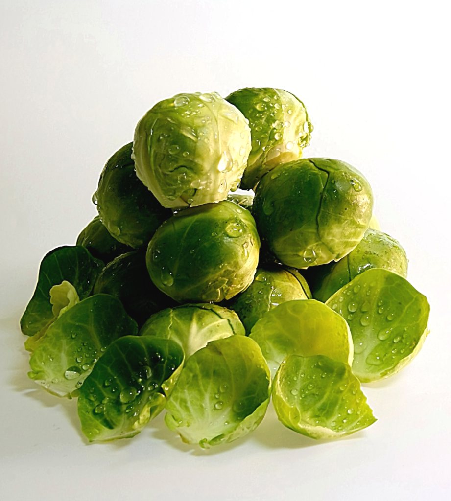 A small pyramid of fresh brussels sprouts doused in water.
