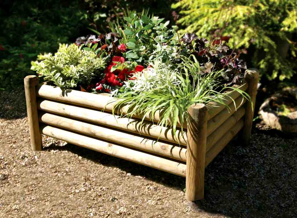 Raised garden bed made from round posts fastened together.