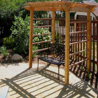 Small two-person seat pergola ready to welcome vine plants