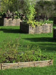 Height raised garden beds of different sizes in a lawn-covered plot.