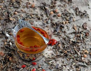 Goji berries steeped in water with an elegant spoon.