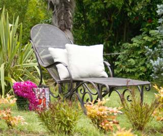 A lawn chair with comfortable pillows in an affordable garden setting.