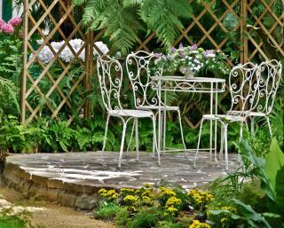 Table set on a raised mound to create volume and space in a narrow garden