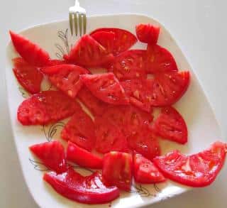 A plate with slices of brandywine tomato