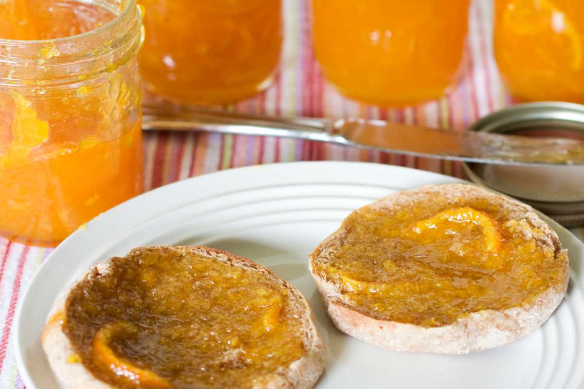 Recipe for orange marmalade, here a sliced muffin with marmalade spread over it