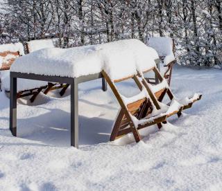 Winter snow on a resin table and garden chairs