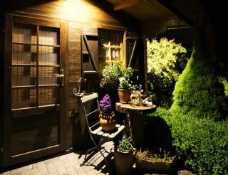 Wooden garden shed at night with cozy seat and table